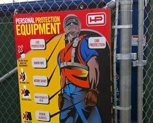 Construction safety signage attached to a chainlink fence.