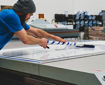Man putting finishing touches on a large format printing project