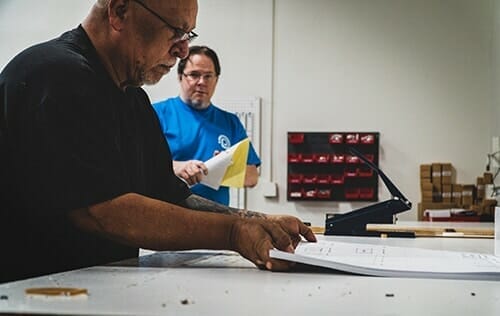 2 PRI Graphics' employees working on a B&W printing project