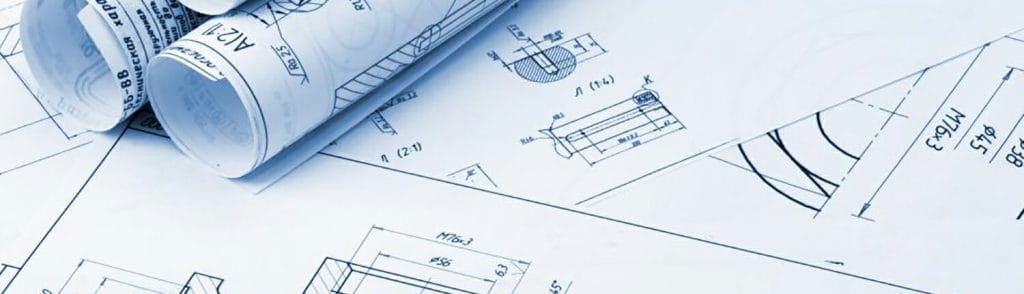 2 rolled up blueprints on top of a flat construction blueprint.