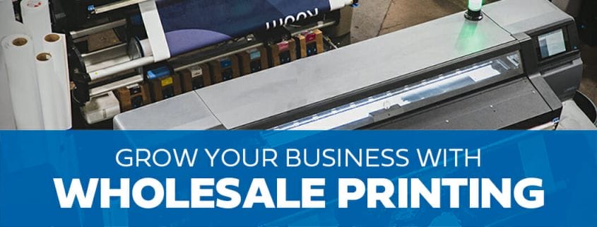 text of "grow your business with wholesale printing" on a blue background with a wide format printer in the further background