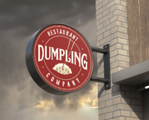 Round printed wall-mounted signage for Dumpling restaurant.