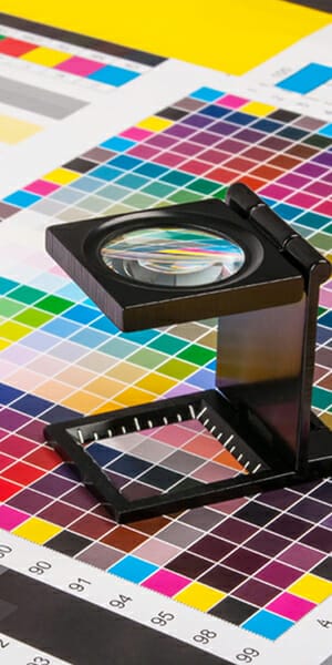 Magnifying glass on a color sample sheet.