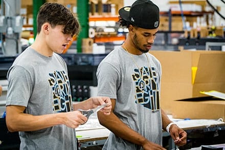 Two PRI Graphics & Signs employees working on a project.