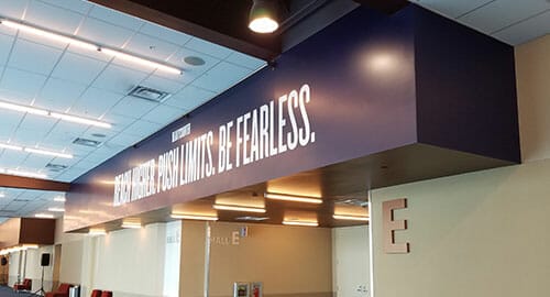 Large vinyl letters displaying a motto above the entrance to a trade show floor.