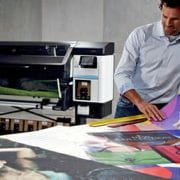 Print operator looking at recently printed posters.