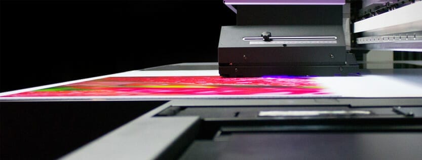 Rigid material being printed on by a UV flatbed printer.