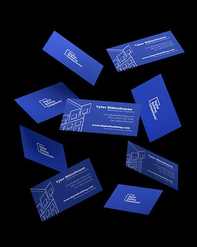 Blue business cards for a building company displayed on a black background.