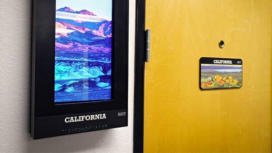 Full-color ADA signage next to an interior door.