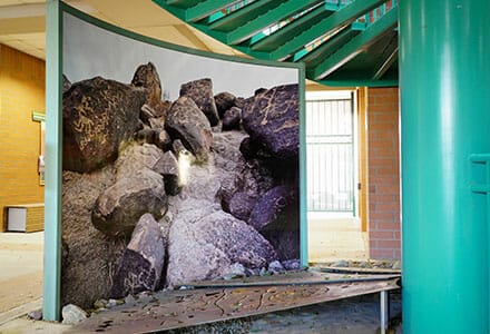 Image of large boulders printed in full color as a wall covering on a curved interior wall.