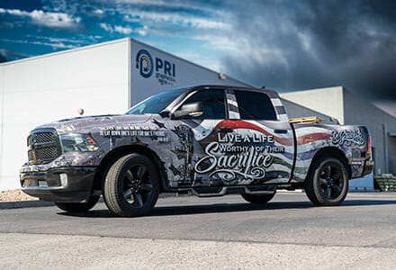 Full truck wrap with vinyl graphics for a Dodge Ram parked outside a printing company.