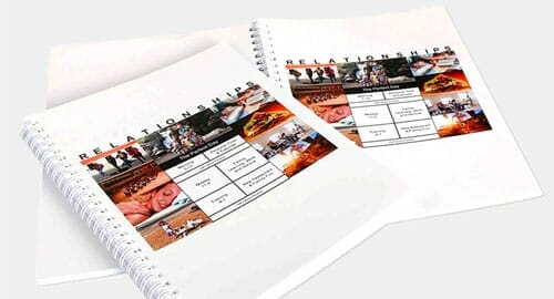 Coil-bound booklets displayed on a white table.