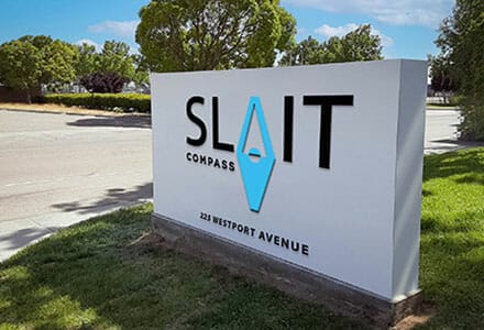 Simple monument sign in green grass featuring the company name.