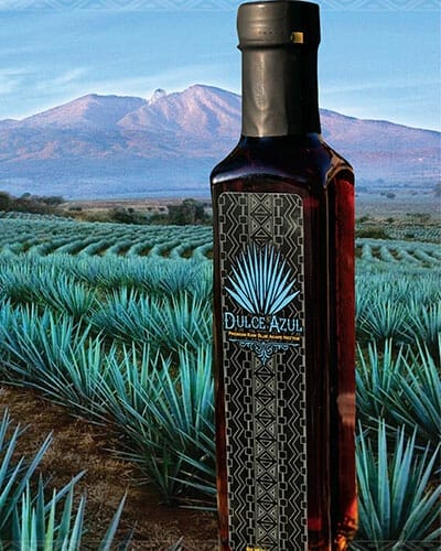 Printed bottle label on organic liquids bottle with a scenic landscape in the background.