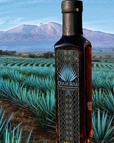 Printed bottle label on organic liquids bottle with a scenic landscape in the background.