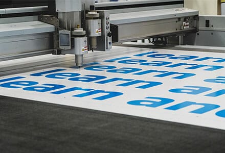 Zund routing machine cutting vinyl letters out.