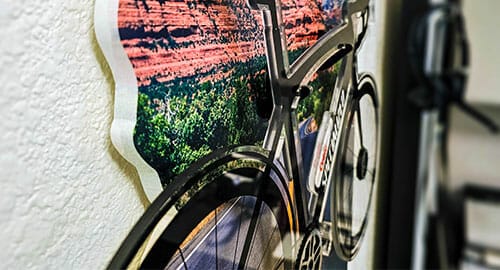 Custom acrylic bicycle cutout hung from a piece of white sintra.