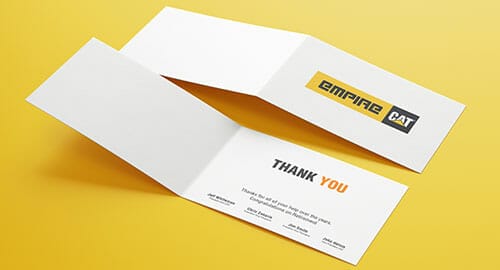 Simple white folded thank you card on a yellow table.
