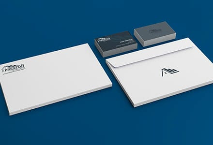 Business stationery for roofing company displayed on a blue table.
