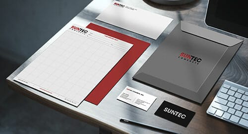 Business stationery products for Suntec Concrete company displayed on a wooden desk.