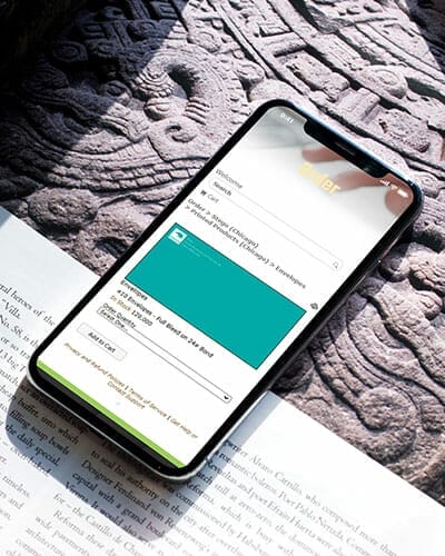 Mobile phone set on a book showcasing web-2-print ordering capabilities.